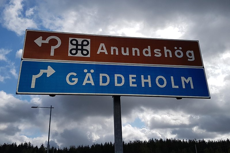 Brun vägskylt med angivelsen Anundshög åt vänster och blå vägskylt med angivelsen Gäddeholm åt höger. Foto: Ingela Lindestad